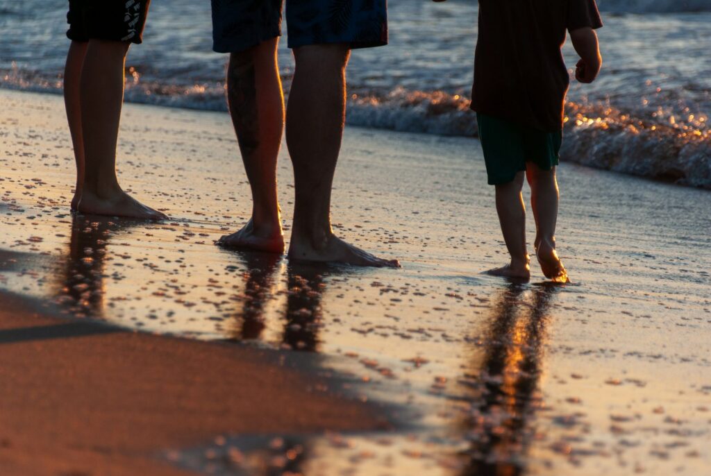 Familie beim Sonnenuntergangsspaziergang am Strand